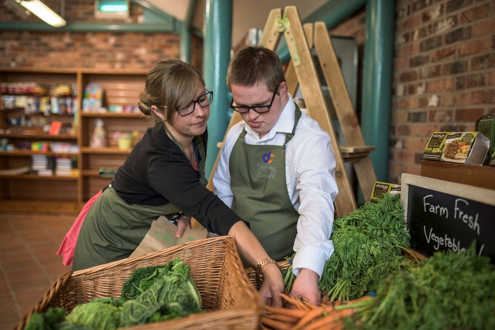 Staff and student put produce on display in Young's Farm shop 2016