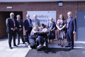 Staff and a student from Derwen stand outside the Bradbury Hydrotherapy Pool with local dignitaries.