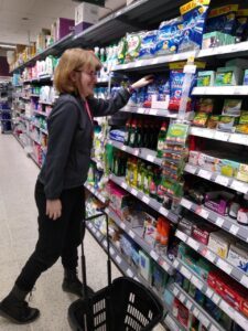 Former Derwen College student in her job at Coop Llanidloes