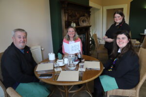 Student Libby and her family sit in the Orangery Restaurant while Jodie takes their order.