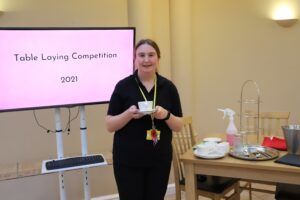 Hospitality student Maisie practices for the table laying competition as part of WorldSkills UK competitions.