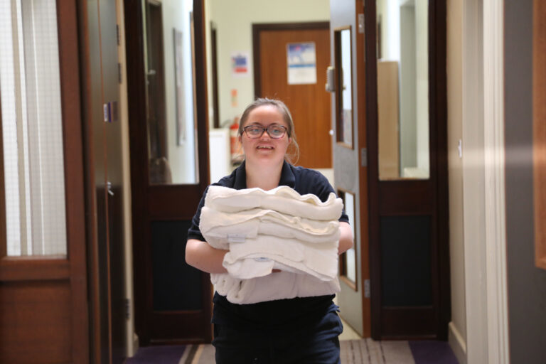 Student carries towels down the corridor at Hotel 751 where you can stay