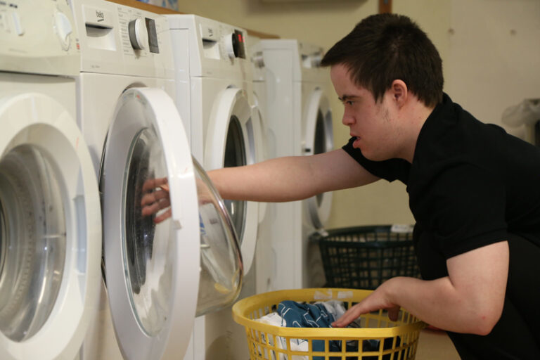student taking items out of the washing machine