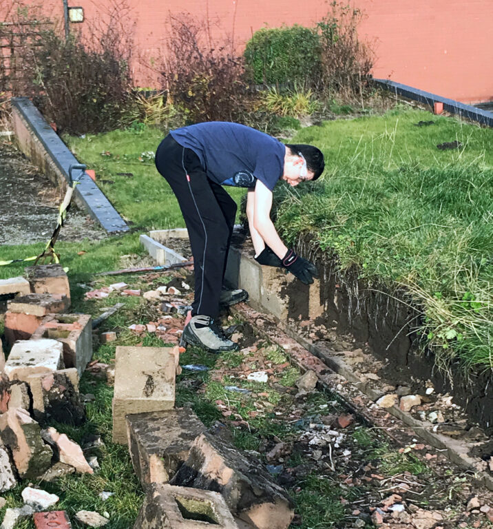 Student removing brick wall