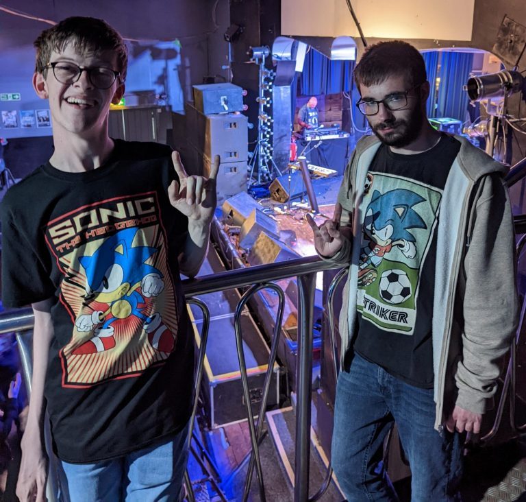 Students Joe and Ethan wearing their Sonic the Hedghog t-shirts on the VIP balcony area at the Hardline gig