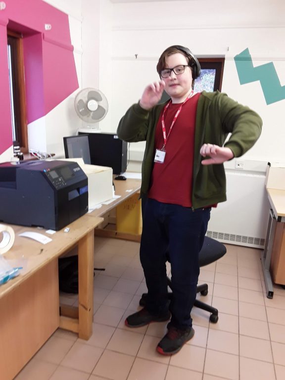 Student JT enjoying using the printing equipment in Karten Print Shop.