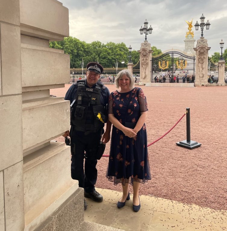 Derwen College Principal Meryl Green pictured with a police officer outside of Buckingham Palace