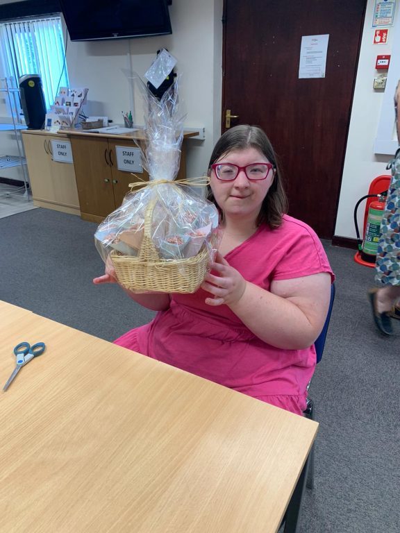 Mia holds a basket of products that she has packaged for her work at ECO Workshop.