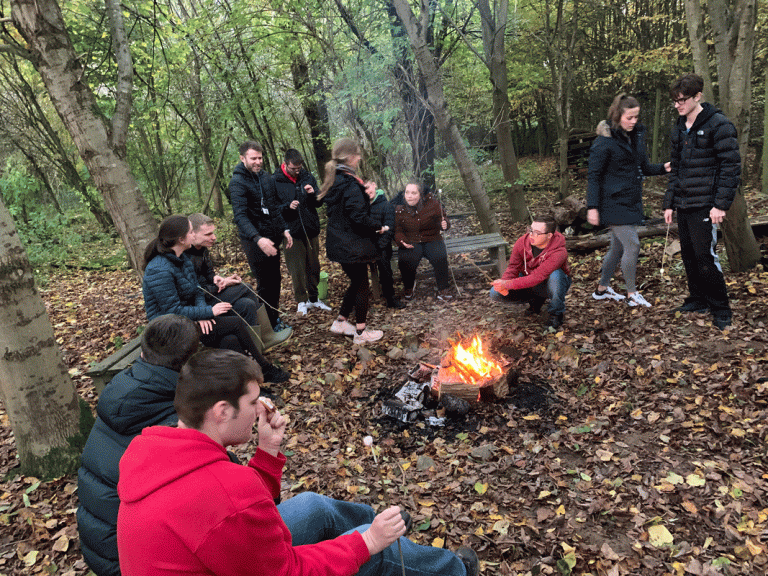 Bronze DofE students enjoying toasting marshmallows around the campfire