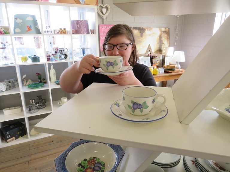 Former retail student Mia displays a vintage cup and saucer as part of her work experience in the College's The Vintage Advantage charity shop.