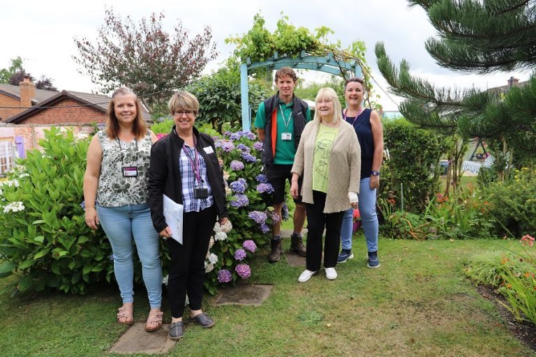 Senior Customer Relations Officer Emma Jones, Julie Burton from Star Housing Ground Maintenance, Will Lyon, and Angela Simpson, Head of Assets., with Best Garden winner Mary Griffiths, from Oswestry., in Mary's award-winning garden.