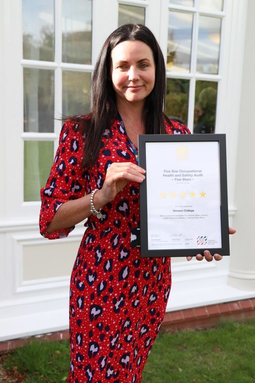 Director Natalie Bellis holds the framed 5-star health and safety certificate