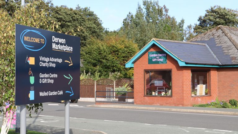 Derwen College Marketplace sign in foreground, and entrance to Garden Centre & Gift Shop in the background