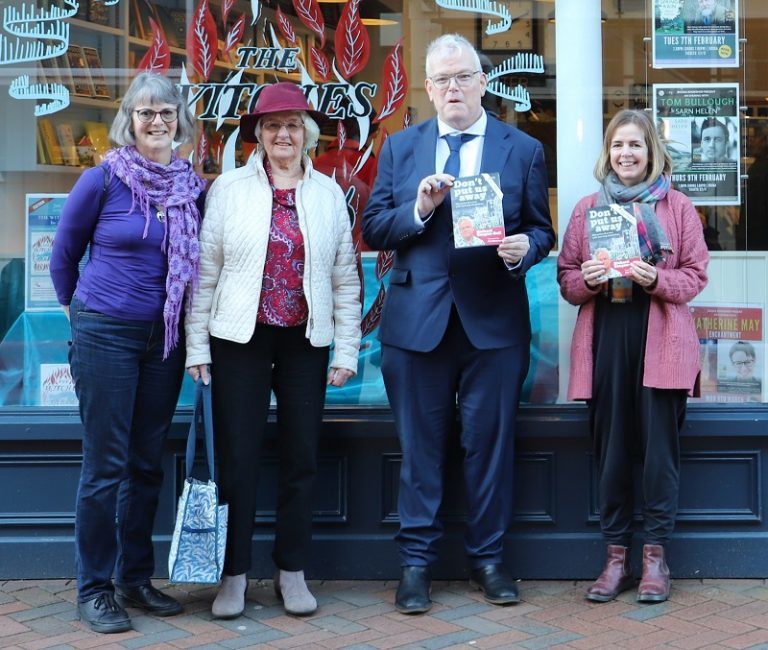 PA Hazel, family friend Yoland, Richard and Booker owner Carrie stand outside Booka bookshop front window holding copies of Richard's book.