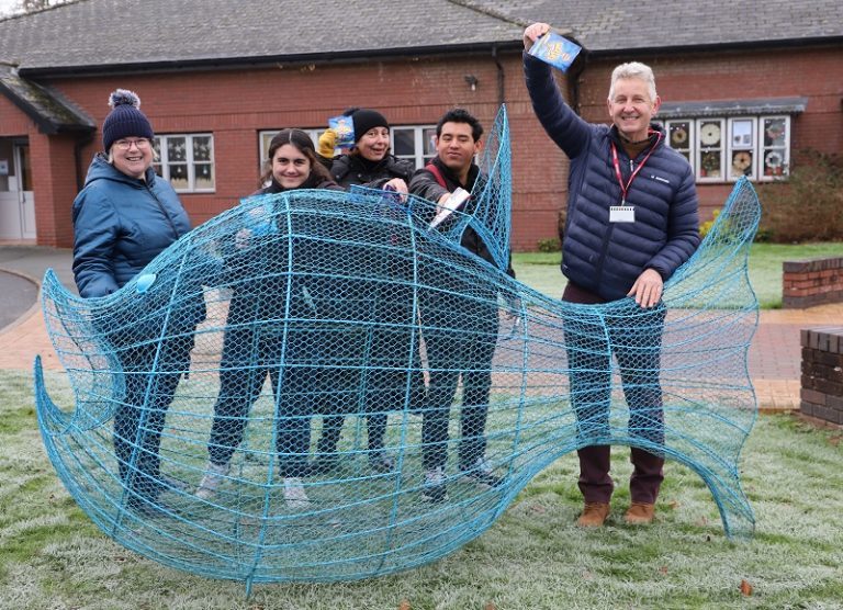 Helen Owen, Varvara Barbieri, Tabetha Crinson, Justin Harley and British Ironworks founder Clive Knowles stand behind a giant blue wire clown fish, holding up crisp packets ready to go into the fish.