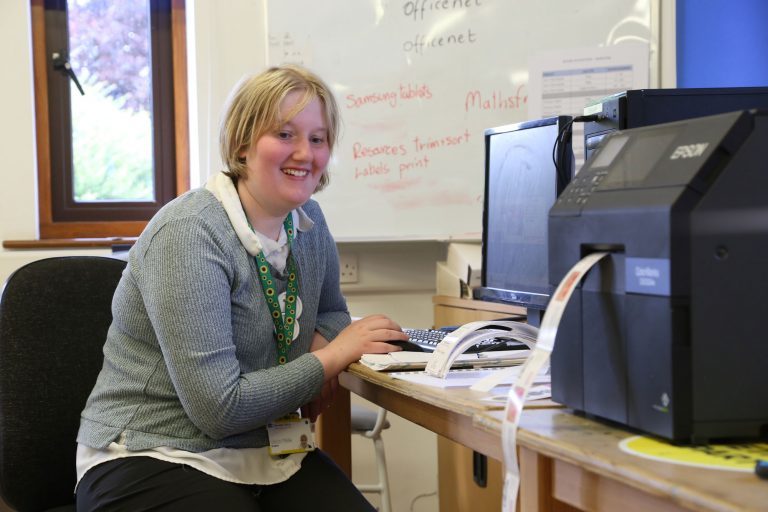 Student working at the computer. Printing labels for products.