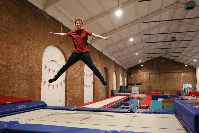 Student bounces high on a trampoline during rebound therapy