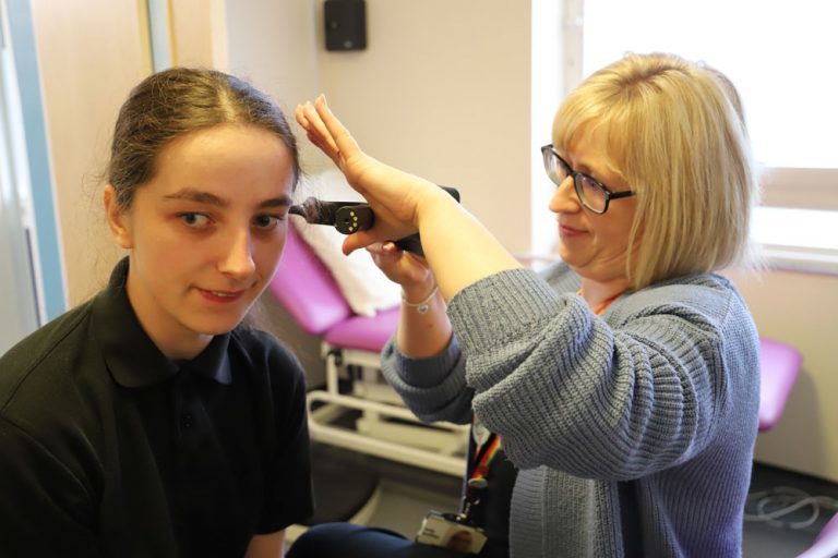 Learning Disability nurse Kelly uses specialist hearing equipment to check the ears of a student