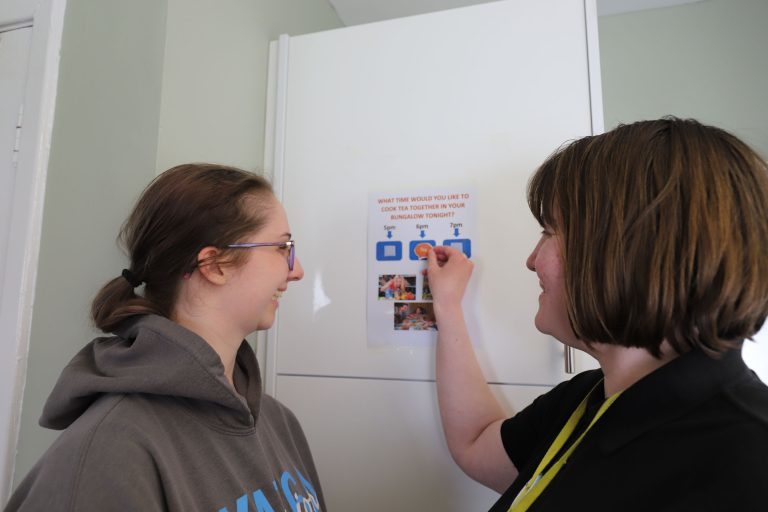 Two students look at a visual prompt about cooking tea