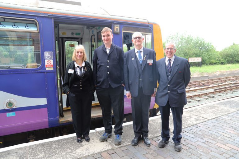 Angie Sanderson (Oswestry Station master), Harry (dressed in smart jacket), Tom Sanderson (CHR Treasurer), Phil Liddell (Volunteer Co-ordinator) stood on the train platform next to the train.