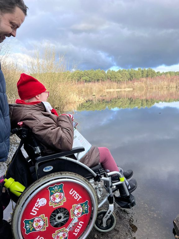 Student in a wheelchair looks out over a lake