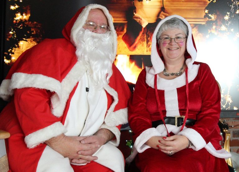 Santa and Mrs Christmas dressed in traditional red and white wait to meet young visitors to Mrs Christmas's Kitchen.