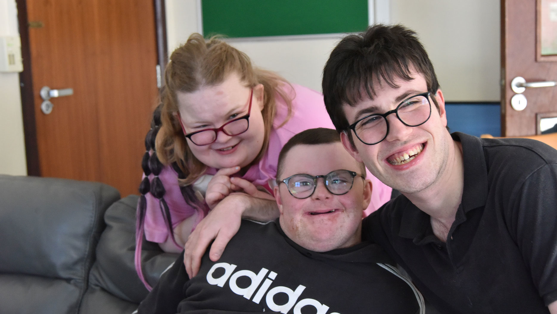 Three people sit together closely