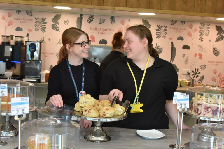 two people serving in a cafe looking at each other