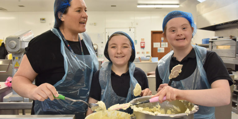 staff and two students in the kitchen