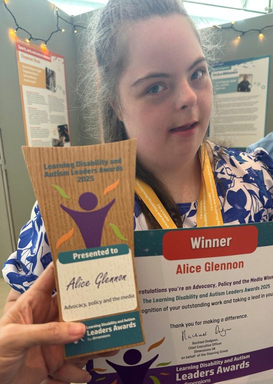 Selfie of Alice holding her certificate and trophy