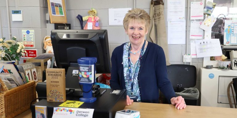 volunteer stands behind the till at the vintage advantage charity shop