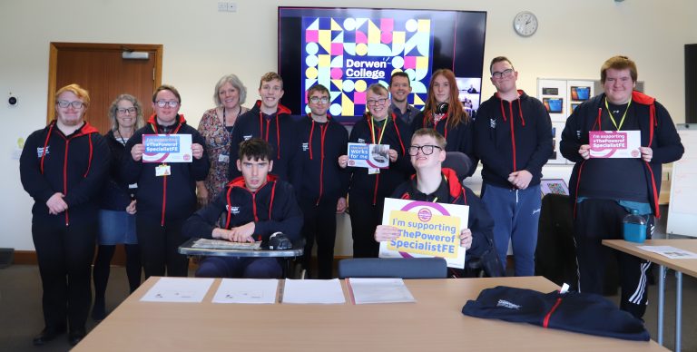 A large group of students all wearing new Student Council hoodies, along with Principal and two college governors, in a meeting room with Derwen College Teams screen, holding 'I'm supporting the Power of Specialist FE boards.