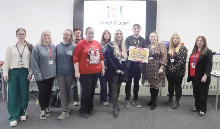 A group of employers, staff and student standing in a row, smiling, stood in front of the Lunch and Learn screen, with student holding a board that says I'm supporting #ThePowerofSpecialistFE