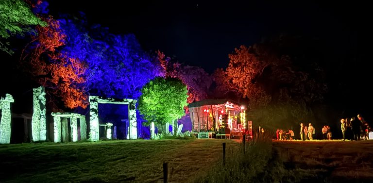 Weston Rhyn's mini 'clone henge' lit up at night in green, blue and red lighting