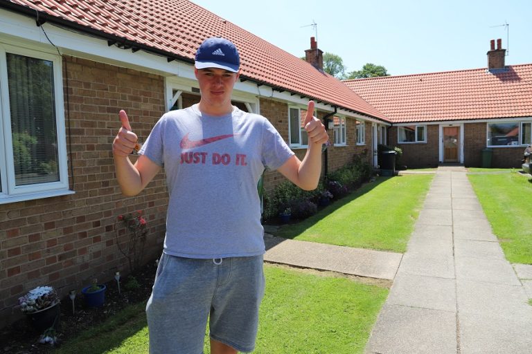Ben outside a bungalow
