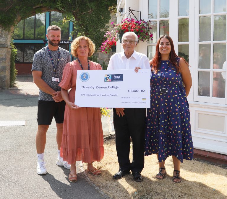 Staff Steve, Becky and fundraiser Bryony accept a giant cheque for £2,500 from Peter Cherrington, outside in the sunshine by the college's Orangery Restaurant.