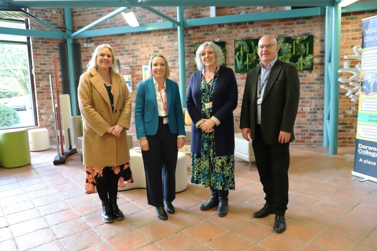 Group photo of three staff members and Helen Morgan standing in college Reception.