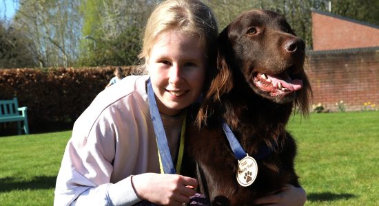 Student Lucy and Teddy the therapy dog crop banner